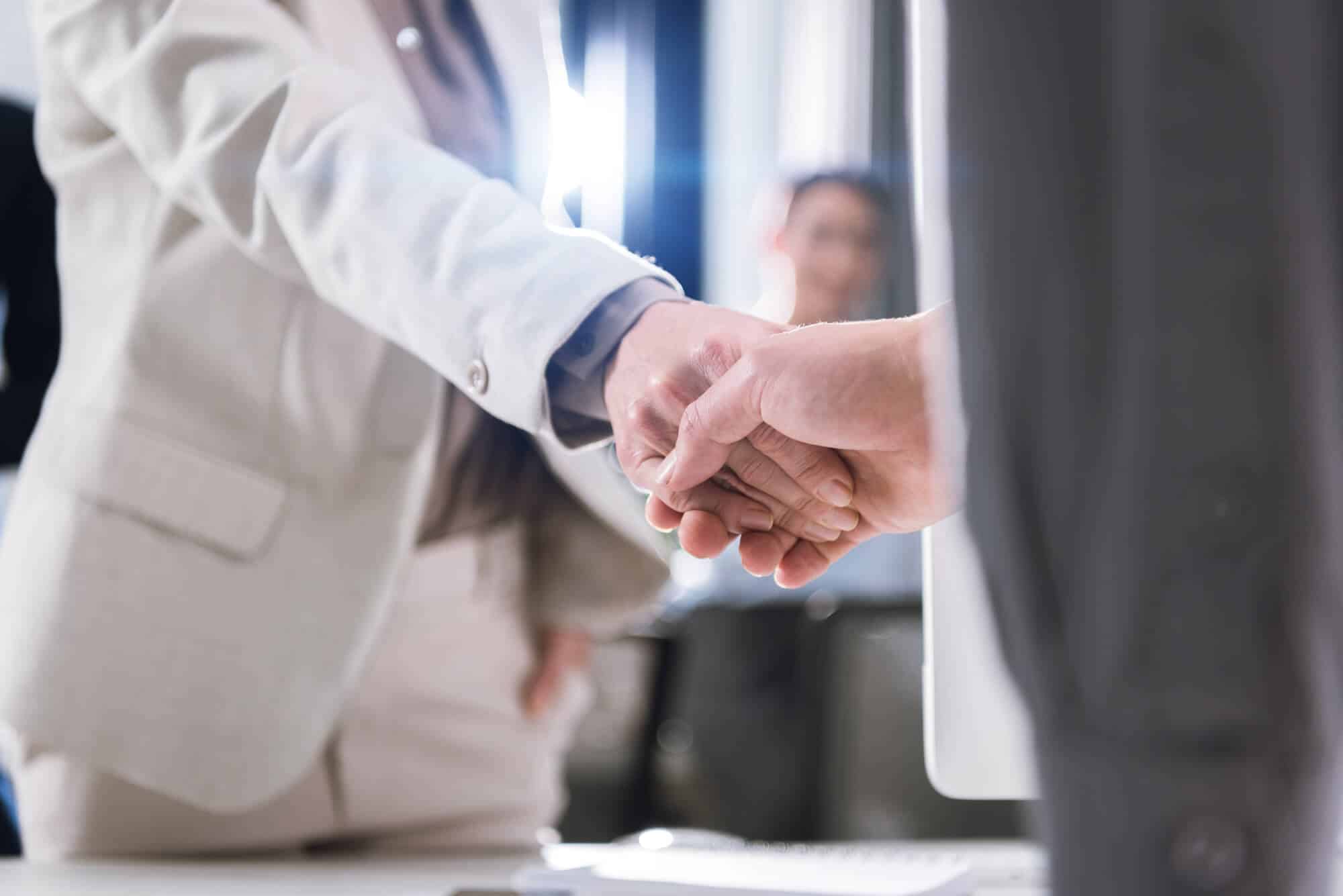 business partners shaking hands after buying insurance agencies for sale in Dallas/Fort Worth TX