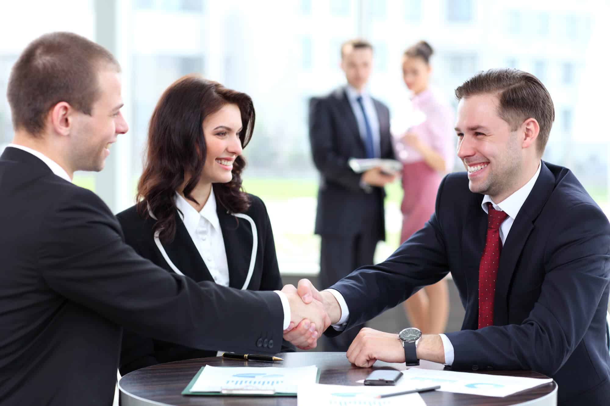 Businessmen shake hands after buying an insurance agency
